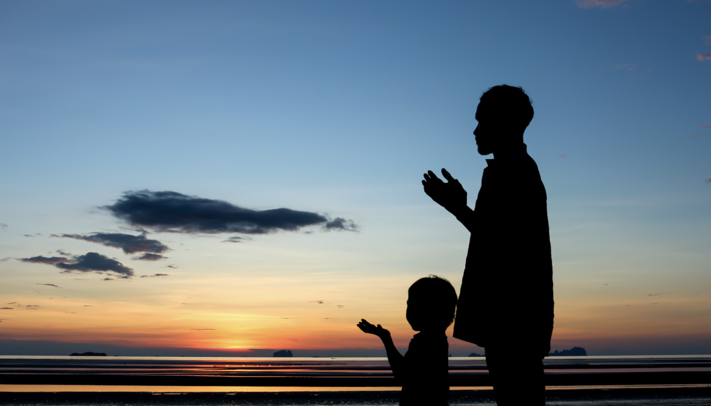 Un père et son enfant prient